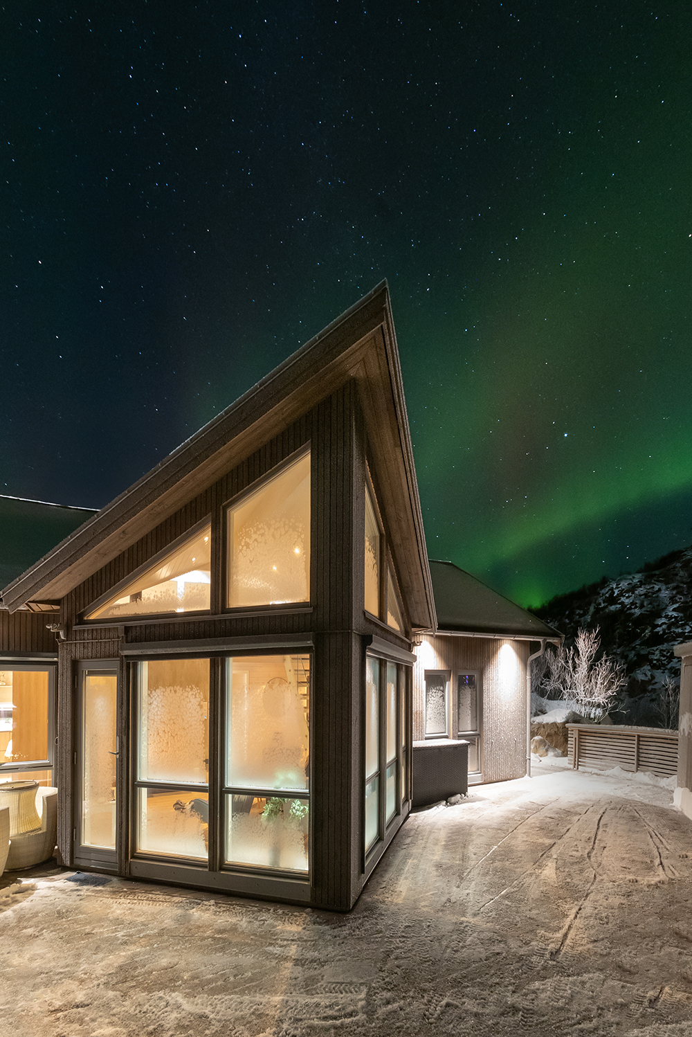 Vikran Seaside lodge stue vindu utenfra med nordlys i bakgrunnen